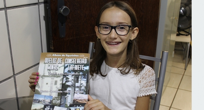 Garota desvenda história de Lafaiete ao completar álbum de figurinhas